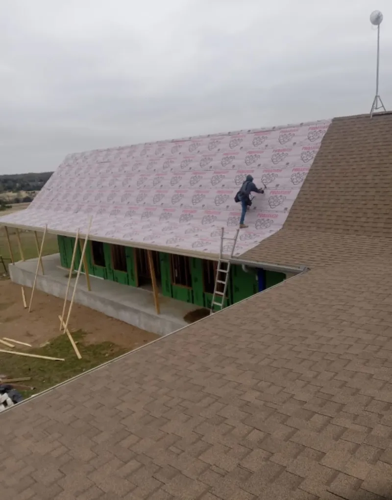 Worker preparing underlayment for a metal roof installation in Jacksonville